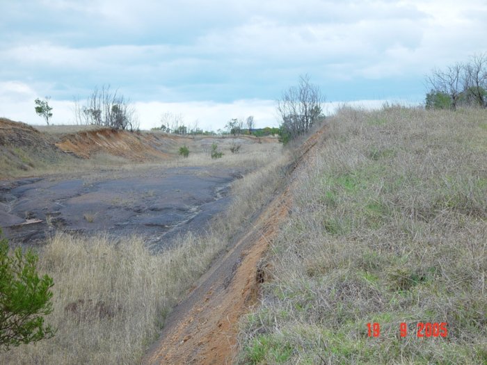 The cleared cutting area near where the line approaches the freeway.