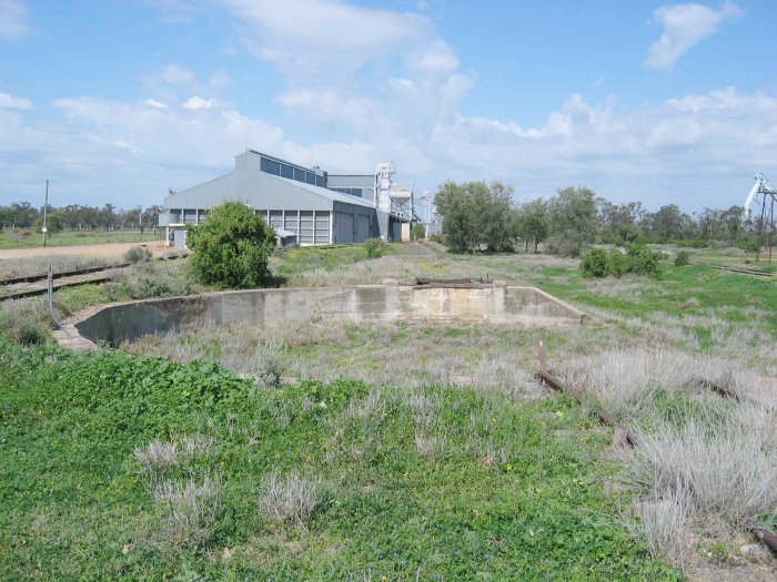 The remains of the turntable pit, facing south.  The main line is visible on the far right.  The line on the left is the old coal road dead end.