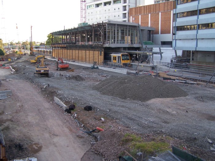 The view south from the eastern end of the temporary footbridge, showing the new platforms in the half-constructed station building, and in the foreground, the site of the other island platform.