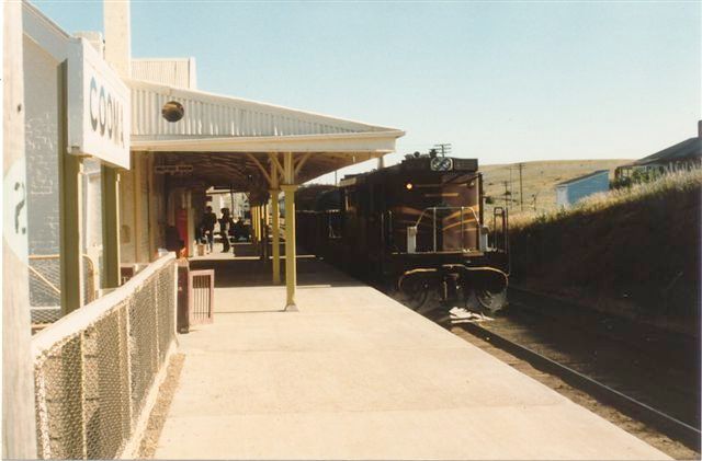 
A tuscan-liveried 48-class loco sits alongside the station.
