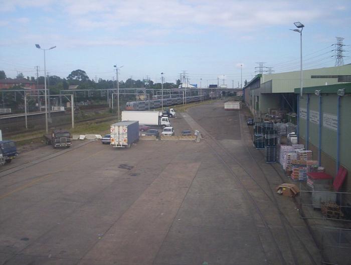 
The view looking west from the footbridge. The track on the right is the
Coles Siding. The track to the left of the Coles Siding is No. 3 Siding.
The 8-car V set is on an extended shunt from Flemington Depot.
Flemington station is visible at the far left.
