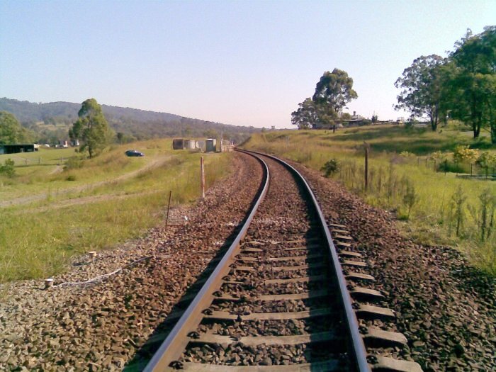 A view from the level crossing looking towards Maitland,  with Hilldale station and makeshift carpark in the background.