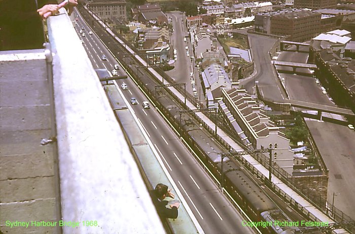 The view looking down from the south-east pylon of the Harbour Bridge, as a city-bound service approaches the tunnel and Wynyard station.