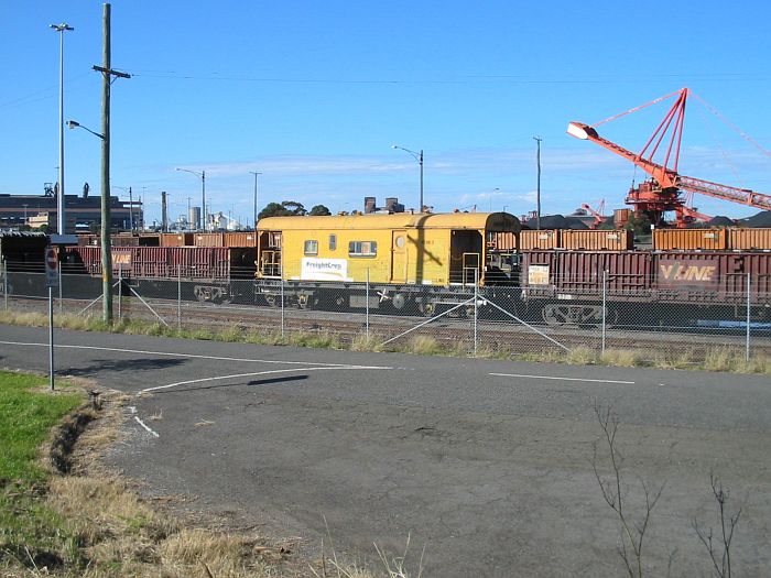 
An old FreightCorp brake van sites between some open V-Line wagons.
