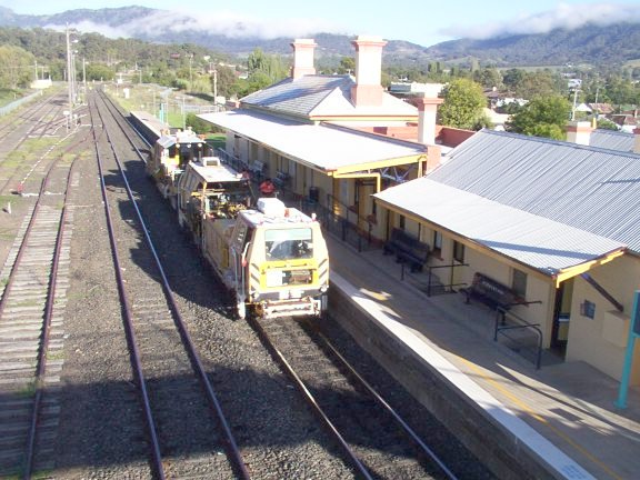 The view looking along the platform in the down direction, with some perway equipment paused on the main line.