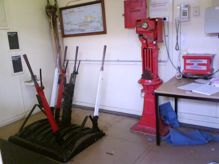 The interior of the signal box, showing the yard diagram, lever frame, and the staff instrument, complete with anti-tamper clamp.