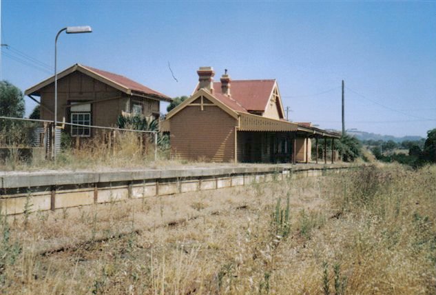 A view looking down the platform at the signal box and station building.